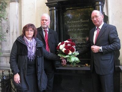 Christa Naaß legt mit Albrecht Schläger und Franz Maget Blumen am Grab von Ferdinand Lassalle nieder.